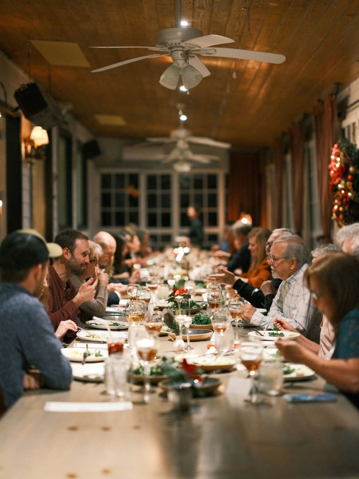 Guests talking along a long, candlelit shared dinner table